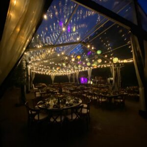 Paper lantern and string light hanging set under a clear wedding tent at night, Riviera Maya